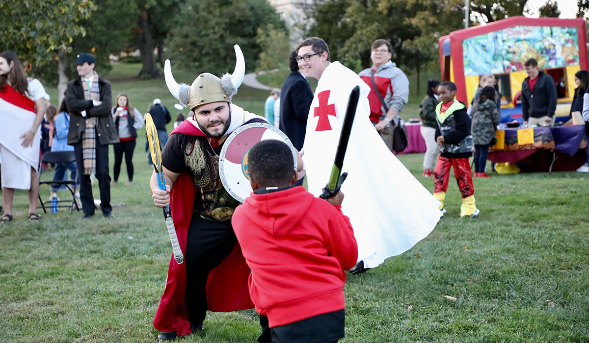 Student jousting with trick-or-treater